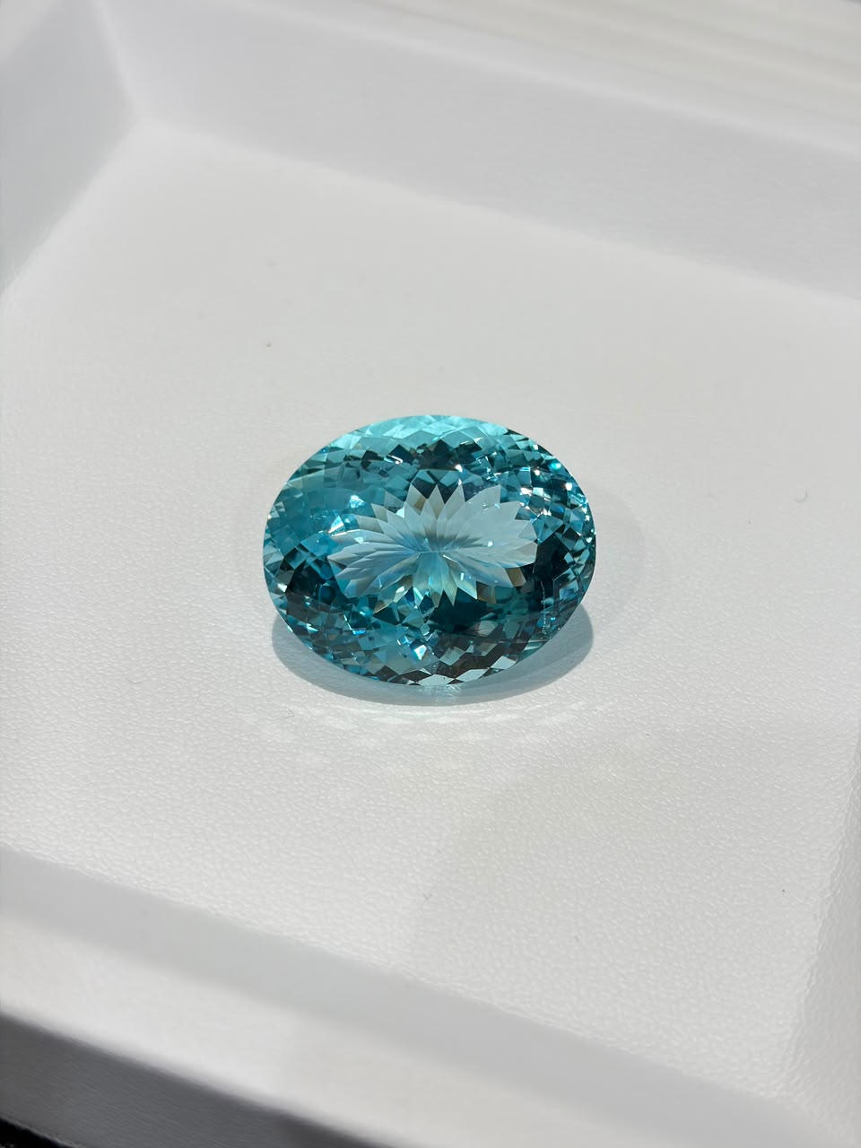 Fan-cut oval aquamarine on a display tray